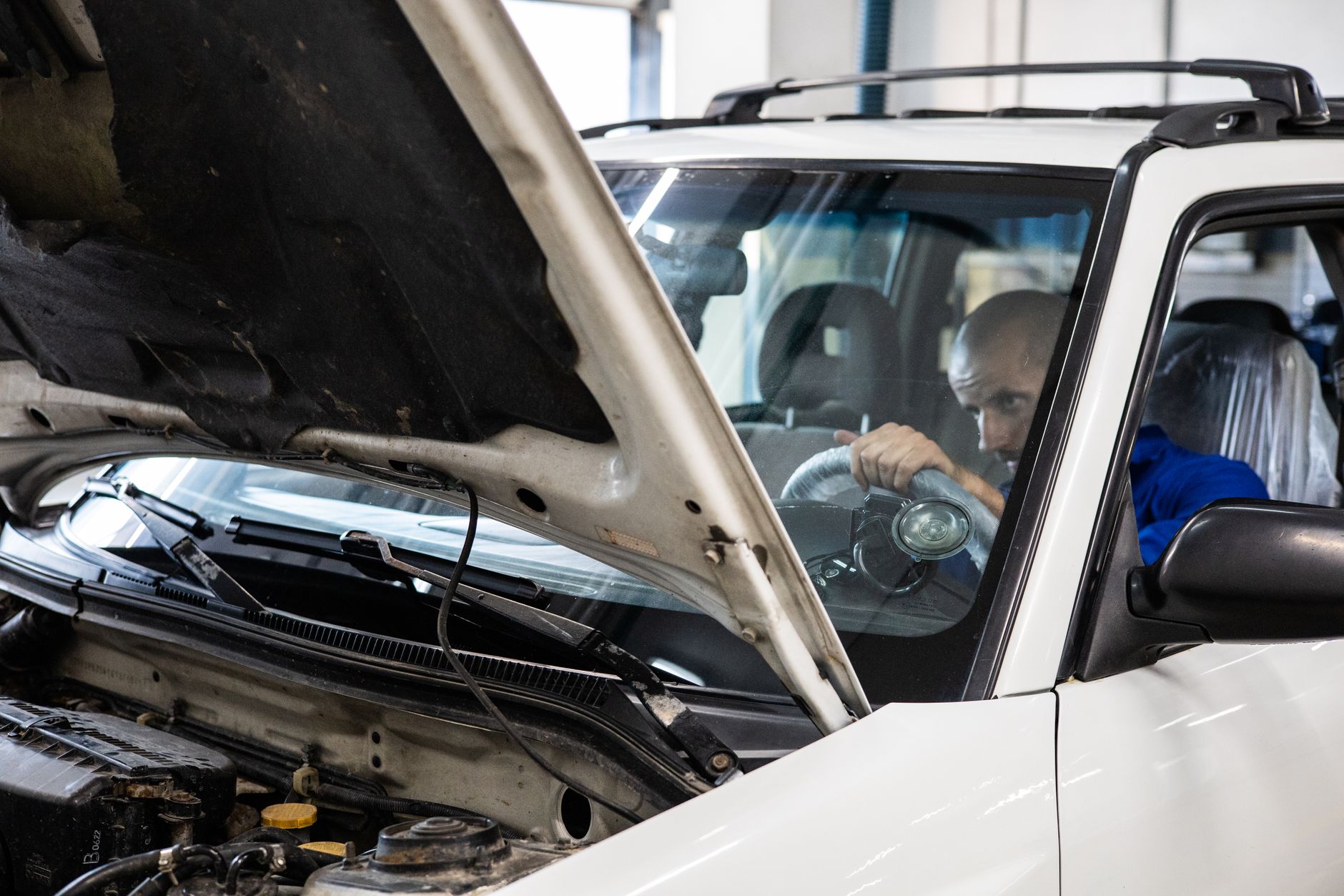 Mechanic inspecting grey import performance car UK workshop
