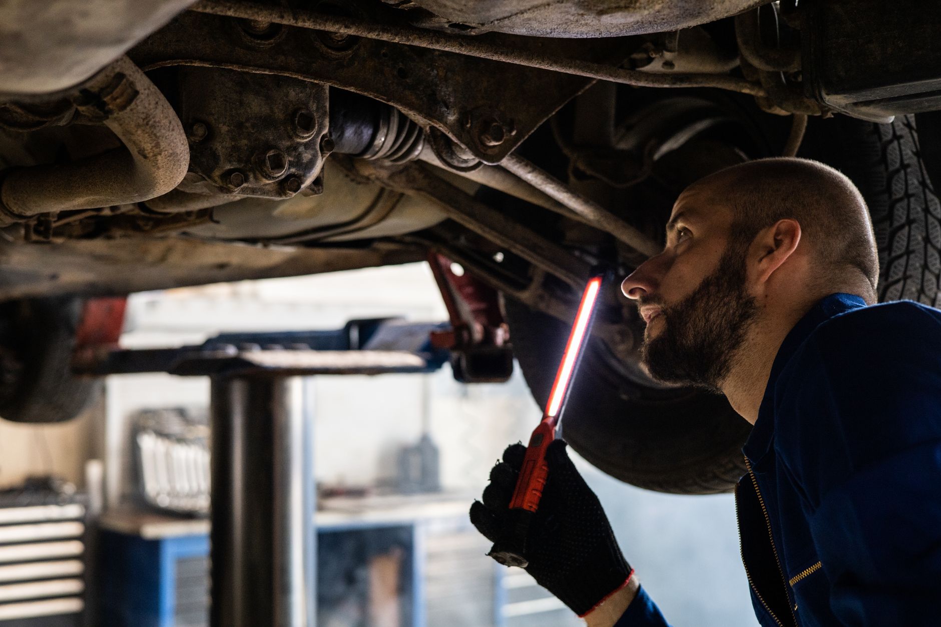Mechanic inspecting suspension components on a modified car as part of a pothole damage claim UK assessment