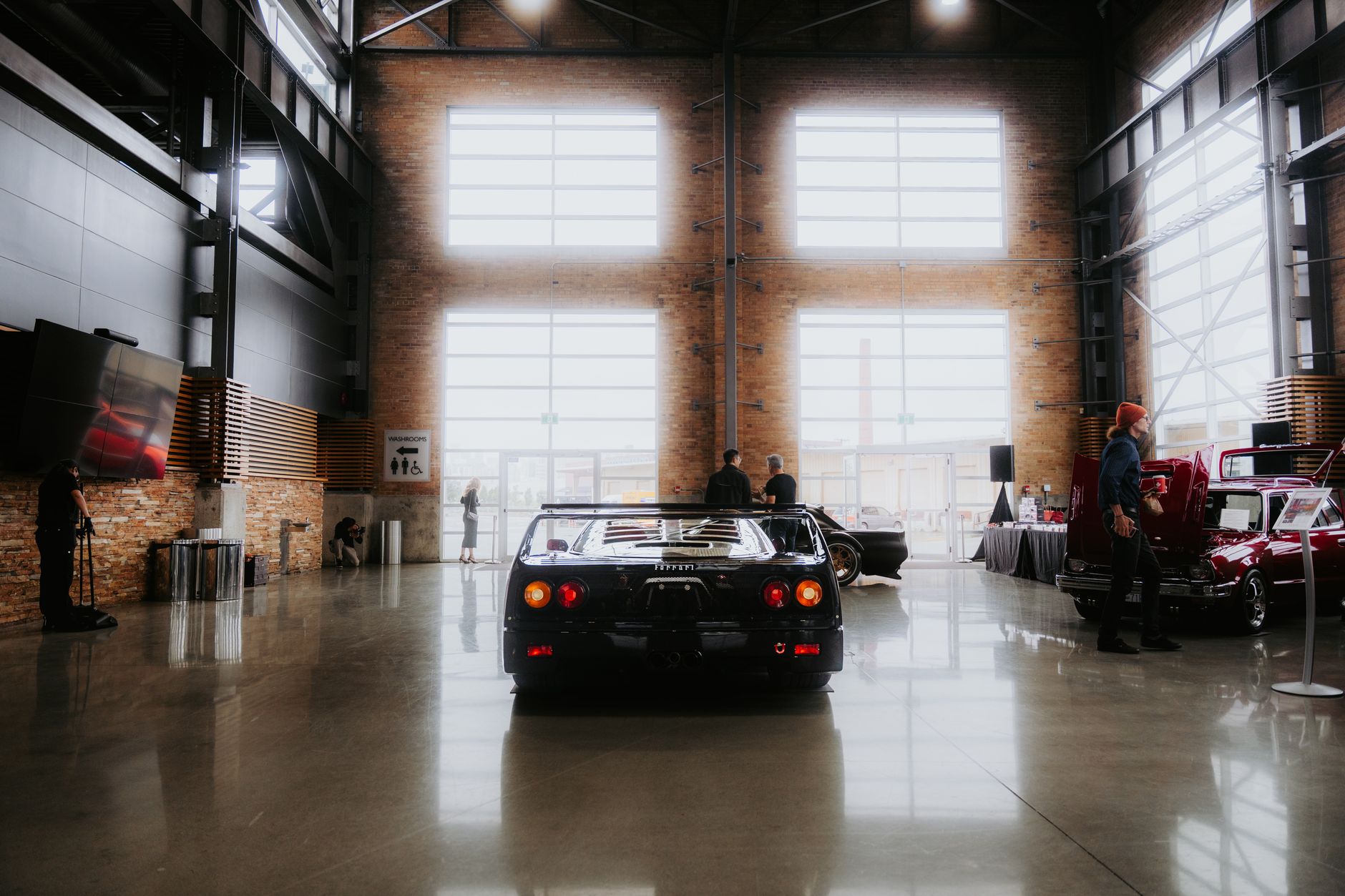 Indoor private car storage facility used by car storage UK enthusiasts with a man checking a trickle charger